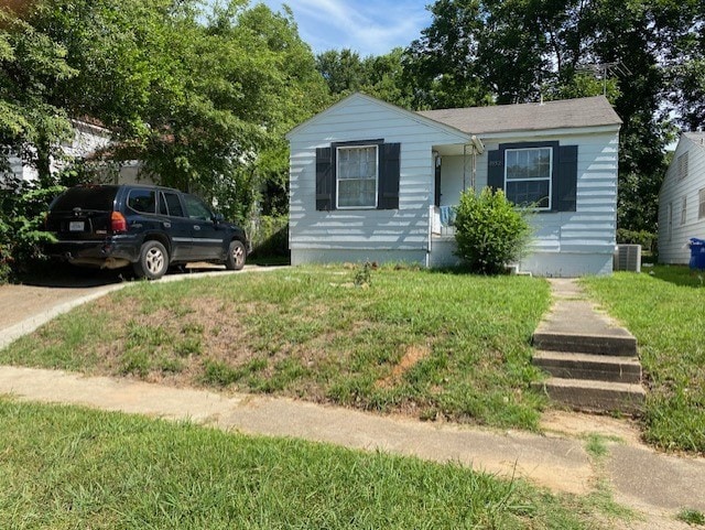 view of front facade featuring a front yard and central AC