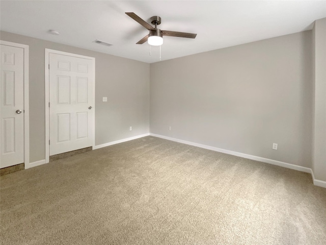 unfurnished bedroom with ceiling fan and dark carpet