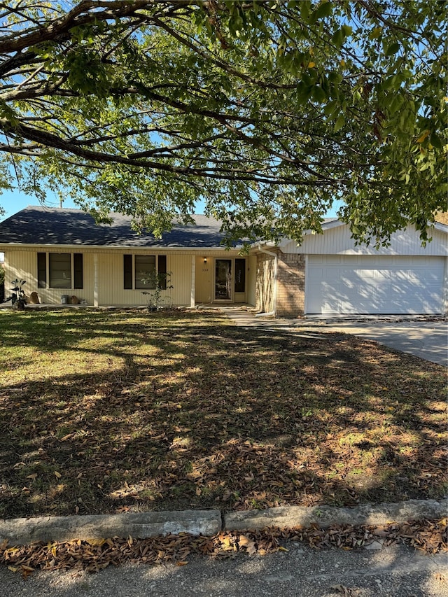 view of front of home with a porch, a front yard, and a garage