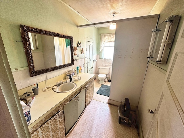 bathroom with tile walls, tile floors, vanity with extensive cabinet space, toilet, and tasteful backsplash