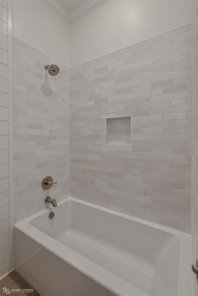 bathroom with tiled shower / bath combo and ornamental molding