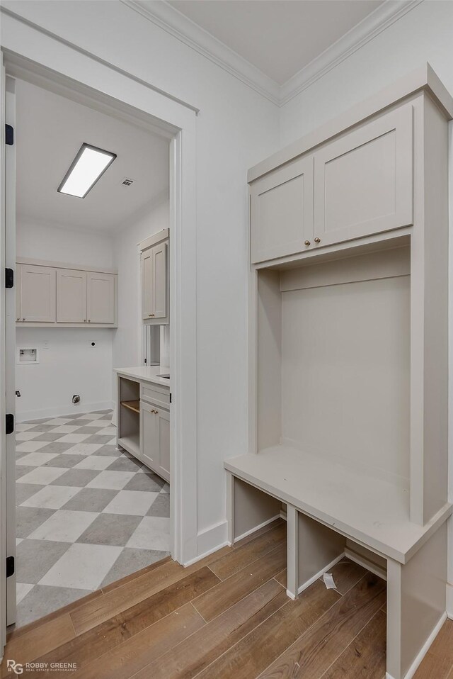 mudroom with crown molding and light wood-type flooring