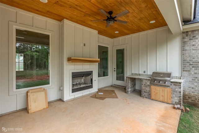 view of patio / terrace featuring a fireplace, area for grilling, and ceiling fan