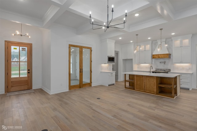 kitchen featuring french doors, custom exhaust hood, pendant lighting, white cabinets, and a large island