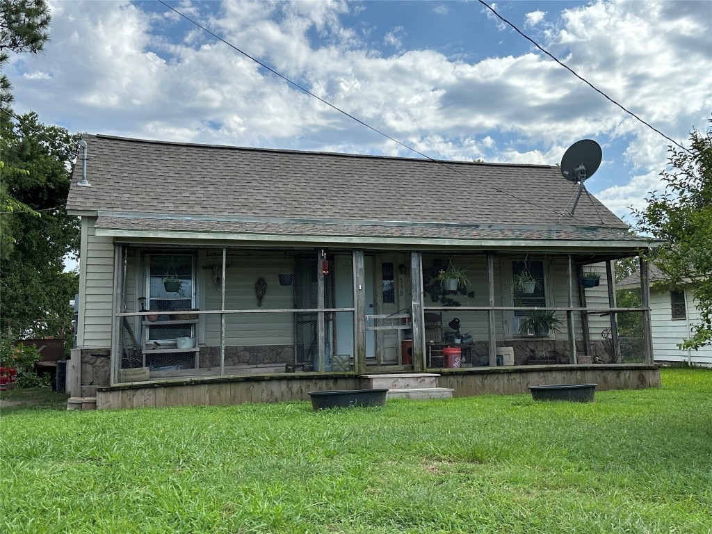 rear view of property featuring a yard