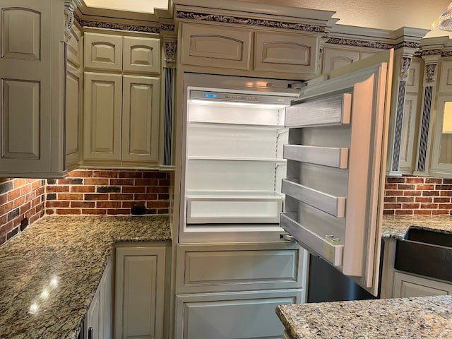 kitchen featuring backsplash and light stone counters