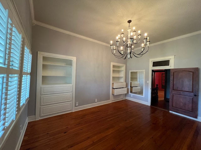 unfurnished room featuring dark hardwood / wood-style flooring, ornamental molding, a wealth of natural light, and a chandelier