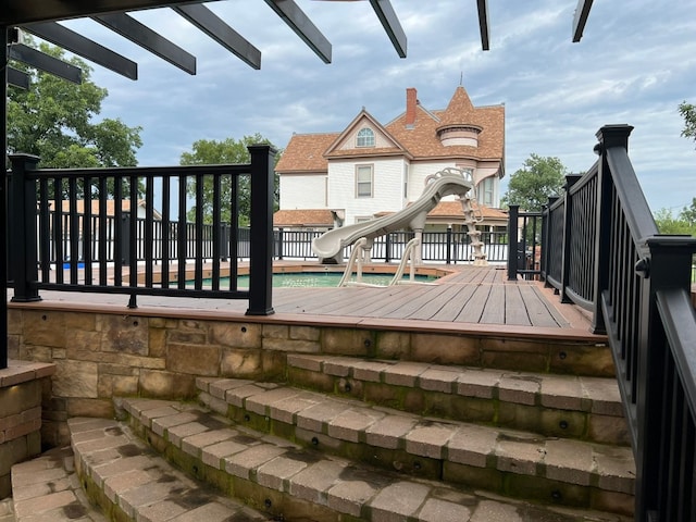 wooden terrace featuring a fenced in pool