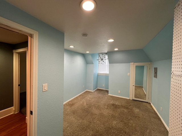 interior space with lofted ceiling and dark colored carpet