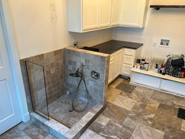 bathroom with tile floors and tiled shower