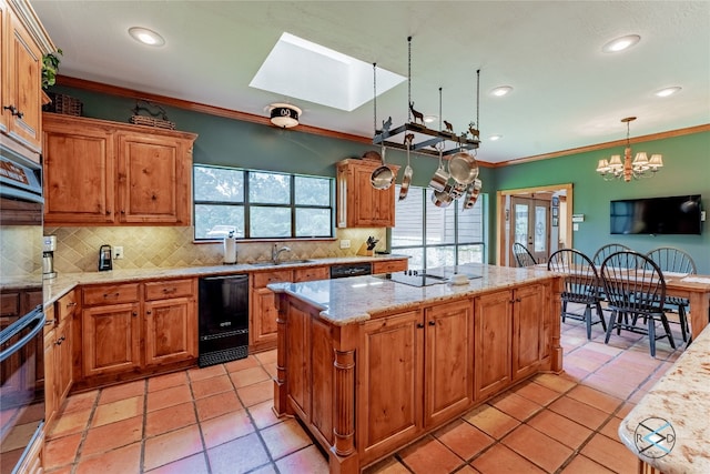 kitchen with tasteful backsplash, a notable chandelier, light tile floors, and a wealth of natural light