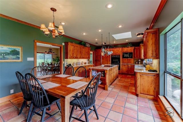 tiled dining room with a skylight, crown molding, a wealth of natural light, and a chandelier