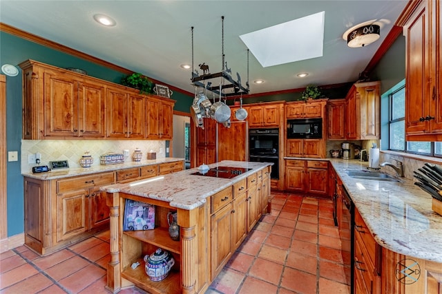 kitchen featuring a center island, light tile flooring, a skylight, tasteful backsplash, and black appliances