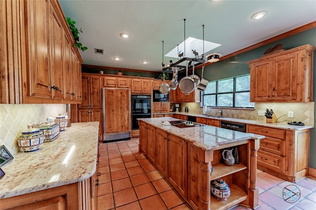 kitchen featuring light stone countertops, black appliances, light tile flooring, a center island, and tasteful backsplash