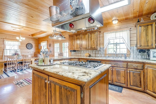 kitchen featuring a notable chandelier, pendant lighting, island exhaust hood, and a wealth of natural light