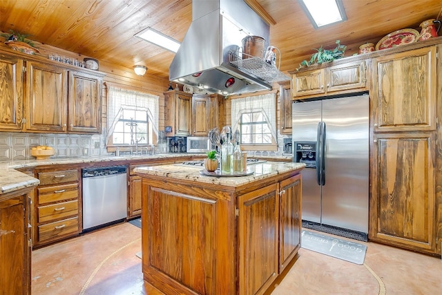 kitchen with stainless steel appliances, a center island, tasteful backsplash, island exhaust hood, and light stone counters