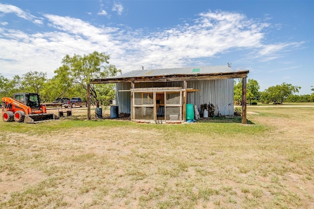 rear view of property with a yard and an outdoor structure