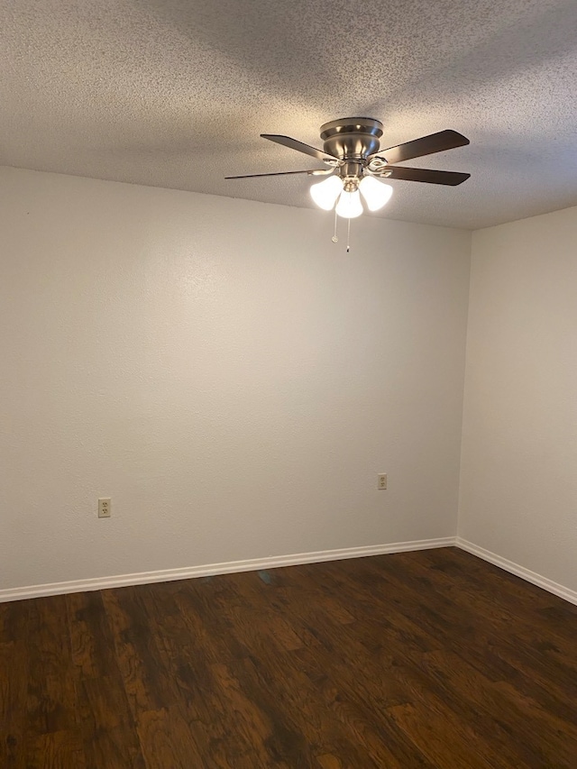 empty room with ceiling fan, dark hardwood / wood-style floors, and a textured ceiling