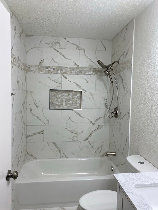 full bathroom featuring a textured ceiling, tiled shower / bath combo, vanity, and toilet