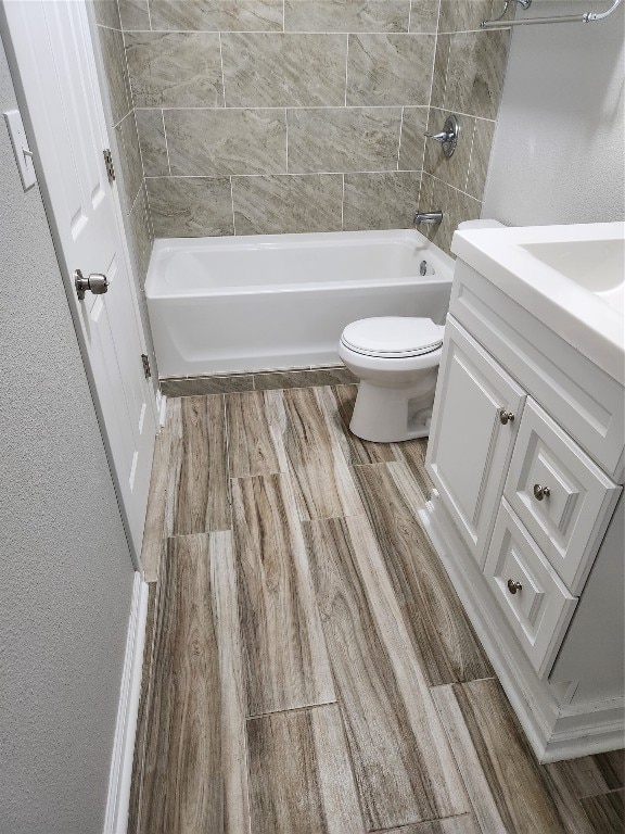 full bathroom featuring toilet, tiled shower / bath combo, and vanity