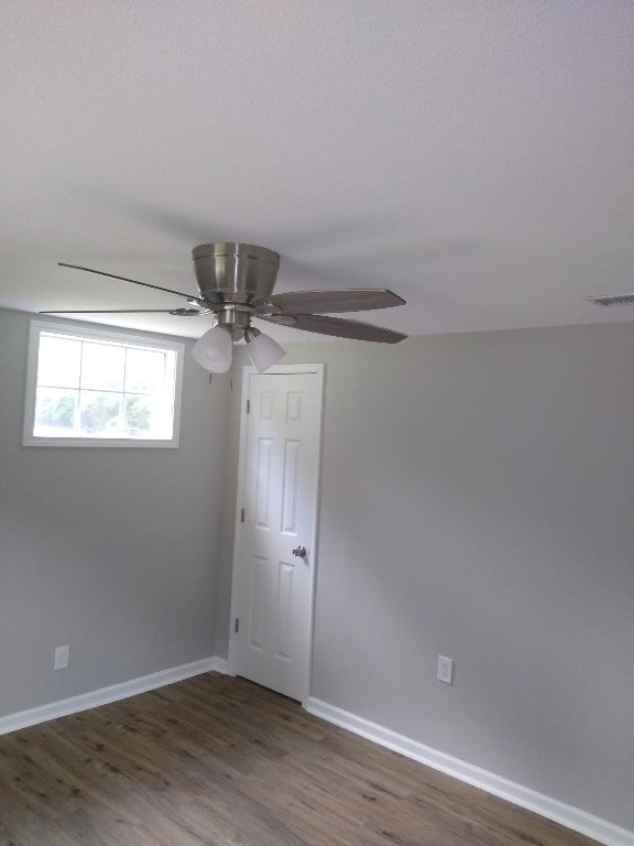 empty room with dark hardwood / wood-style floors and ceiling fan