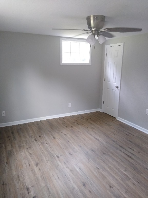 unfurnished room with dark hardwood / wood-style flooring and ceiling fan