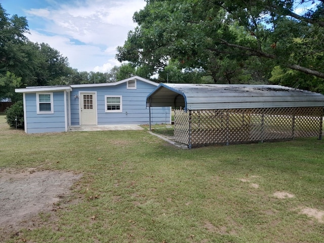 back of property featuring a yard and a carport