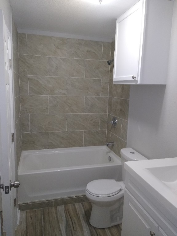 full bathroom featuring vanity, toilet, hardwood / wood-style flooring, and tiled shower / bath