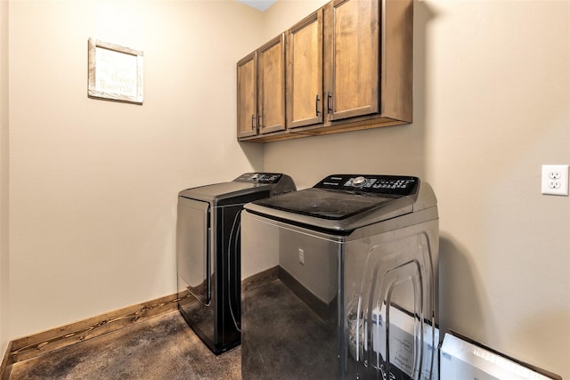 laundry area with washing machine and clothes dryer and cabinets