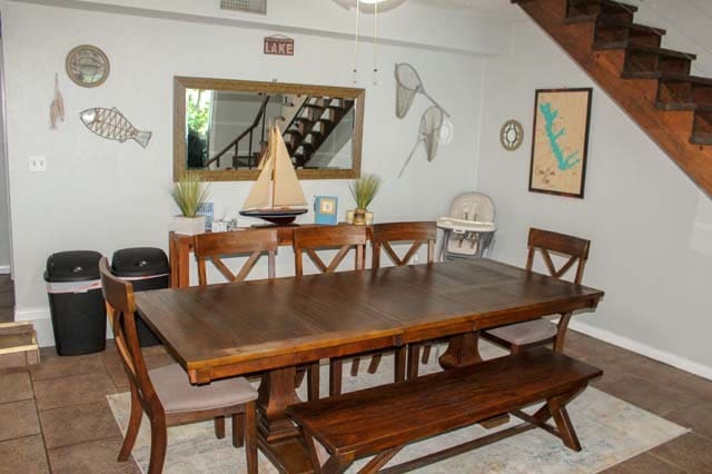 dining room featuring stairs and baseboards