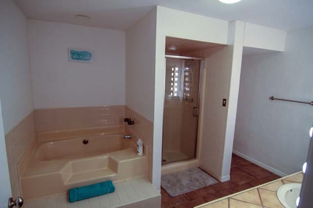 bathroom featuring a shower stall, a bath, and tile patterned floors