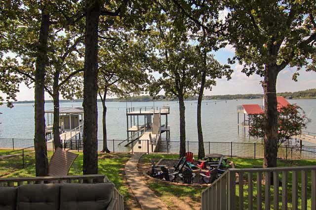 exterior space featuring a water view, fence, and boat lift