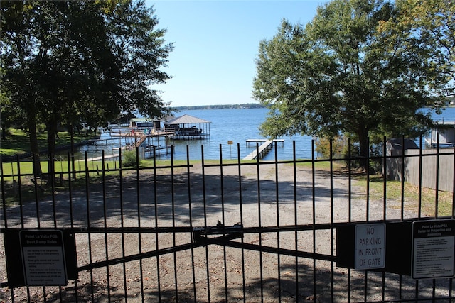 view of gate featuring a water view and fence