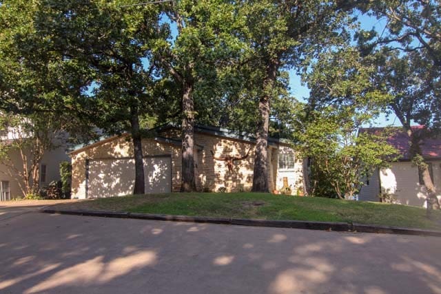 view of front facade featuring a garage, a front yard, and driveway