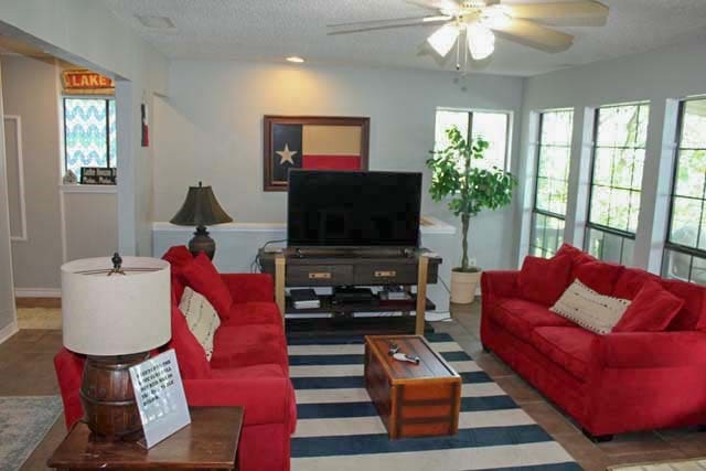 living area featuring a ceiling fan and a textured ceiling