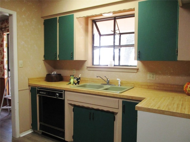 kitchen with dark hardwood / wood-style floors, green cabinets, dishwasher, and sink