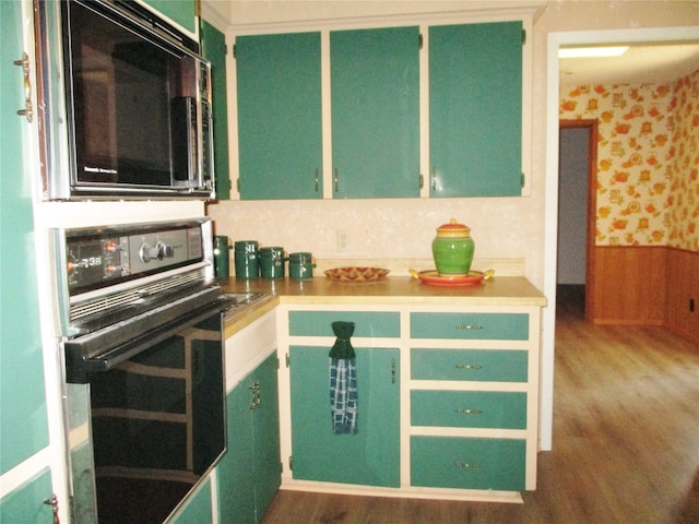 kitchen featuring green cabinetry, stainless steel microwave, dark hardwood / wood-style floors, and oven