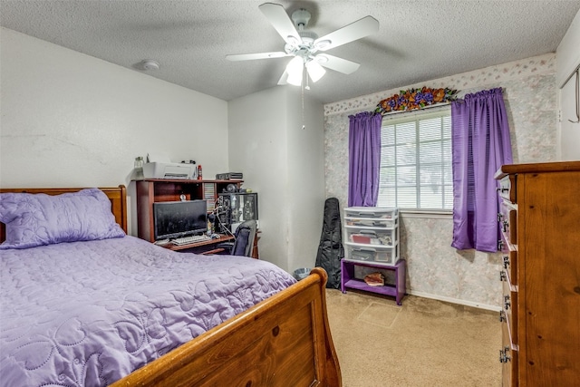 carpeted bedroom featuring ceiling fan and a textured ceiling