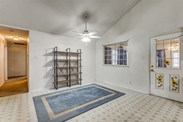 interior space with a textured ceiling, ceiling fan, and high vaulted ceiling