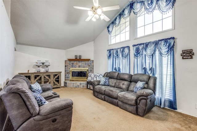 living room with carpet, ceiling fan, vaulted ceiling, and a fireplace