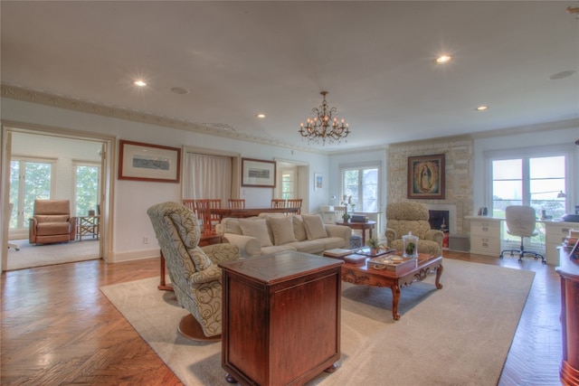 living room featuring a stone fireplace, a chandelier, and light parquet floors