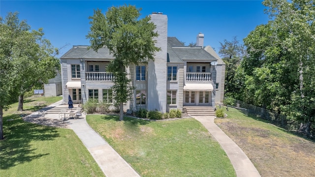 view of front of house featuring a front yard and a balcony