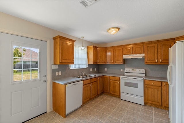 kitchen featuring white appliances, sink, hanging light fixtures, and light tile flooring