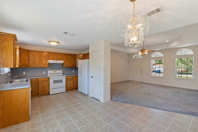 kitchen featuring decorative light fixtures, light tile flooring, white appliances, a raised ceiling, and sink