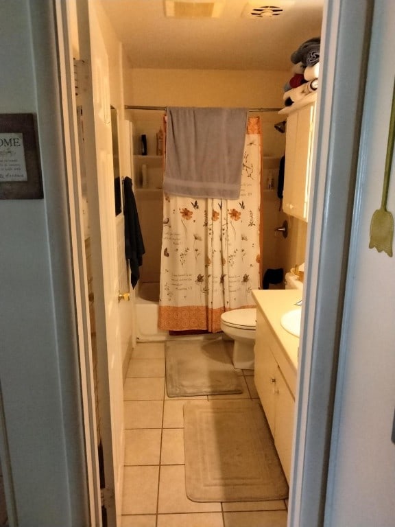 full bathroom featuring vanity, tile floors, shower / tub combo with curtain, and toilet