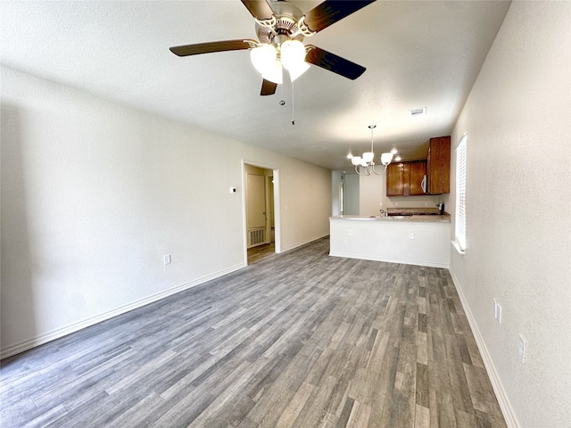 unfurnished living room with hardwood / wood-style flooring and ceiling fan with notable chandelier