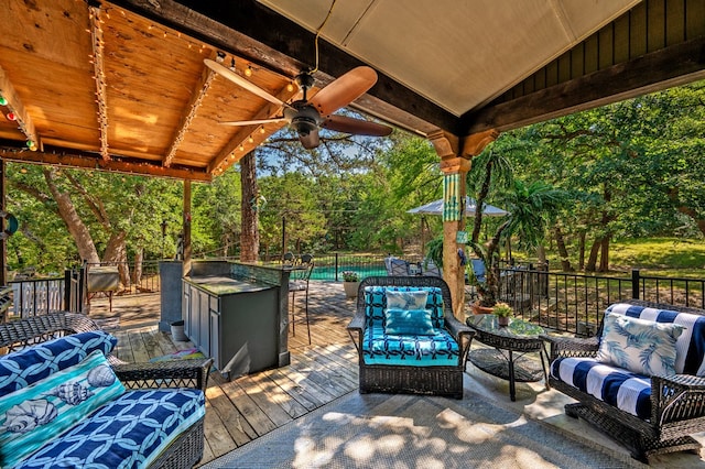 wooden terrace with ceiling fan, an outdoor hangout area, and a pool