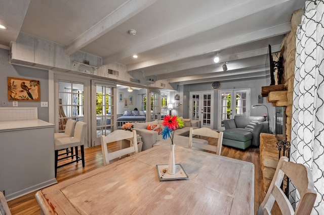 dining space featuring hardwood / wood-style floors, beamed ceiling, and french doors