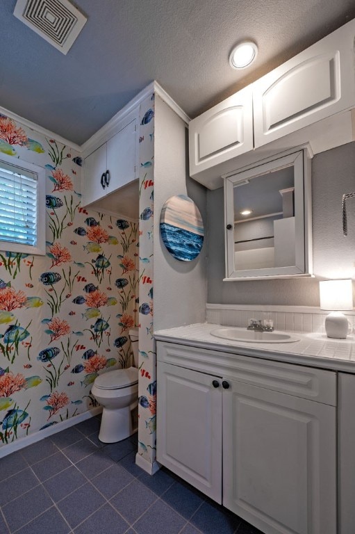 bathroom featuring vanity, tile flooring, a textured ceiling, and toilet