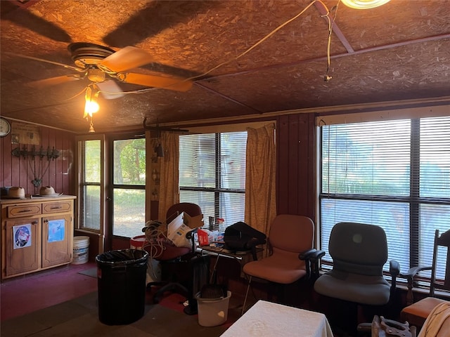 home office with wooden walls and ceiling fan